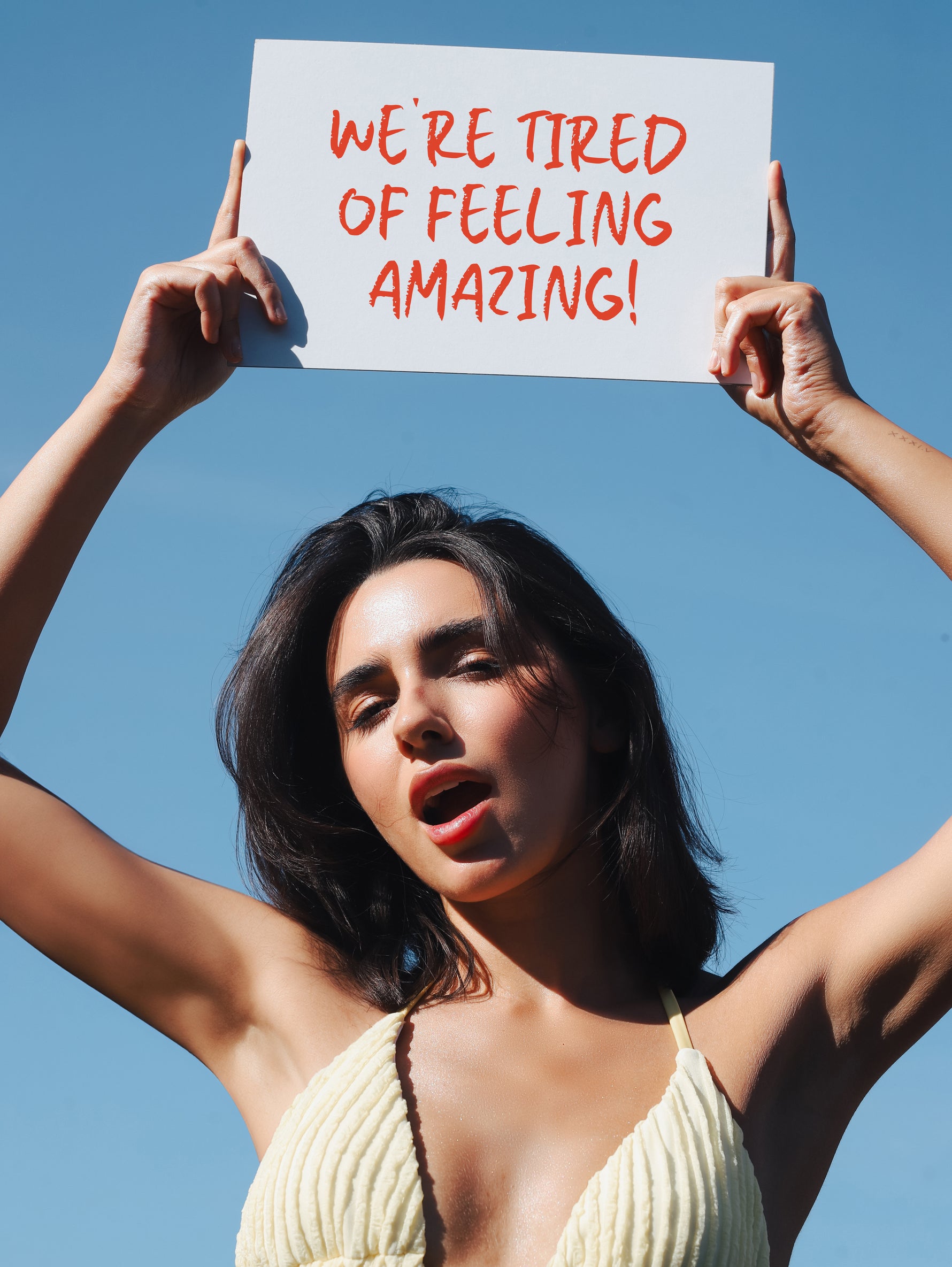 Woman holding a sign with text against a clear blue sky