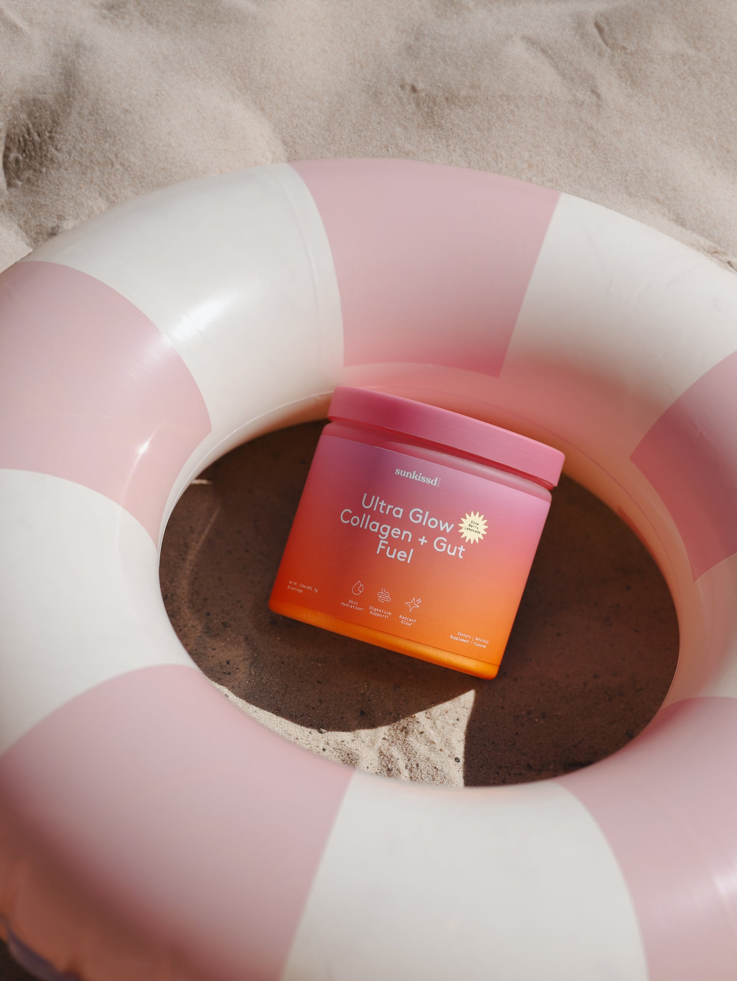 Ultra Glow Collagen + Gut Fuel jar held against a bright blue sky with collagen powder above the open jar.