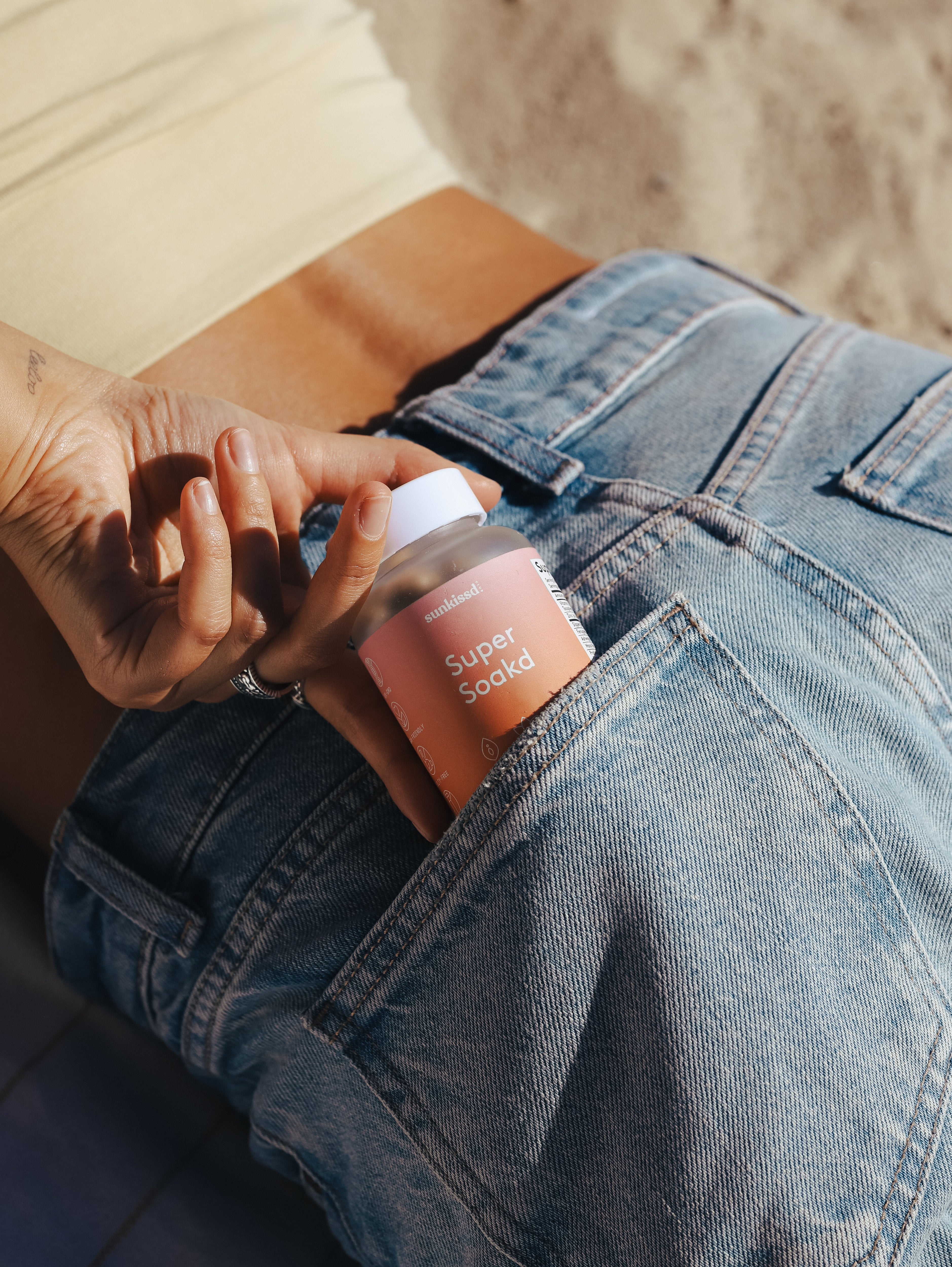 Person putting a bottle labeled 'Super Soakd' into their pocket.