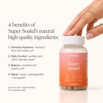 A bottle of Super Soakd herbal supplement capsules held by a hand with manicured nails and gold rings, next to text detailing the benefits of its natural ingredients on a clean white background.